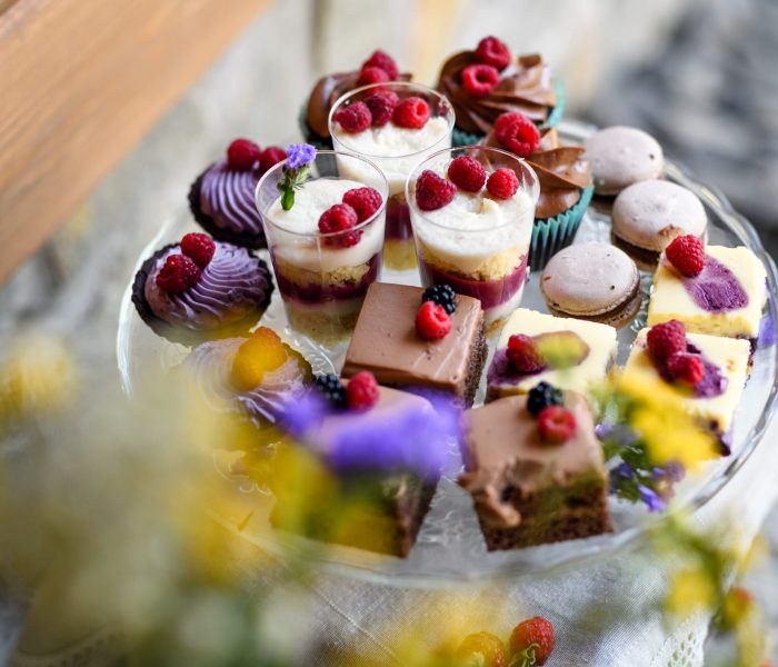 A top view of selection of colorful and delicious cake desserts on tray on table.